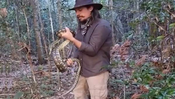 мужчина в шляпе со змеей в руках